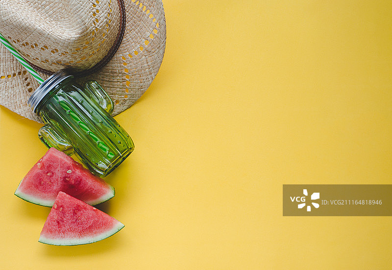 夏天用西瓜，帽子和果汁容器在黄色的背景。的概念……图片素材