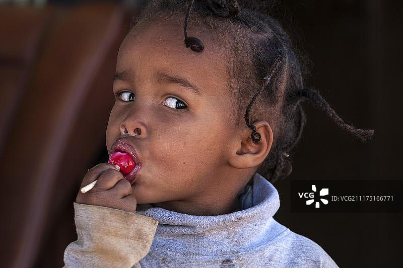 当地女孩拿着红色棒棒糖，肖像，纳米比亚，非洲图片素材