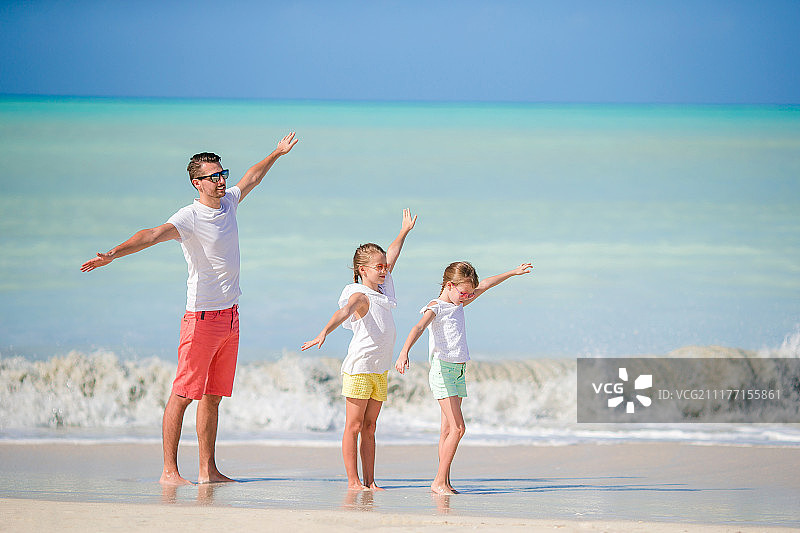 父亲和孩子们享受海滩夏天热带度假家庭在海滩上玩图片素材