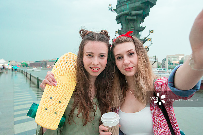 两个潮人城市女孩与滑板户外在日落光近距离滑板在女性图片素材