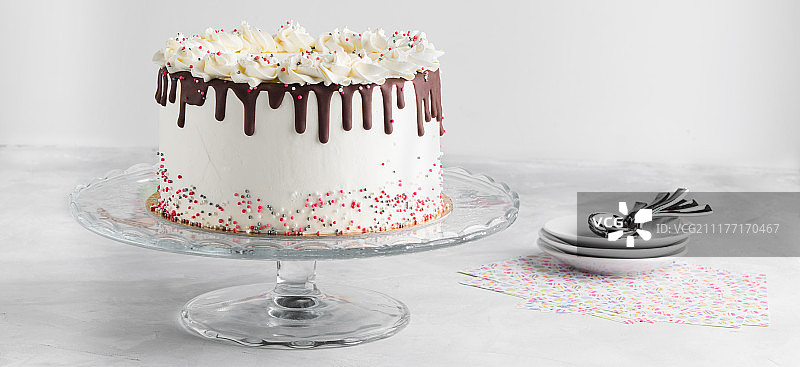 简单的生日滴蛋糕与巧克力甘纳许和点缀在一个白色的背景横幅图片素材