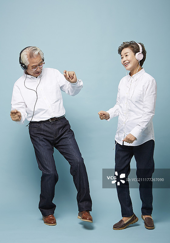 老年夫妇听音乐时戴着耳机跳舞的照片图片素材