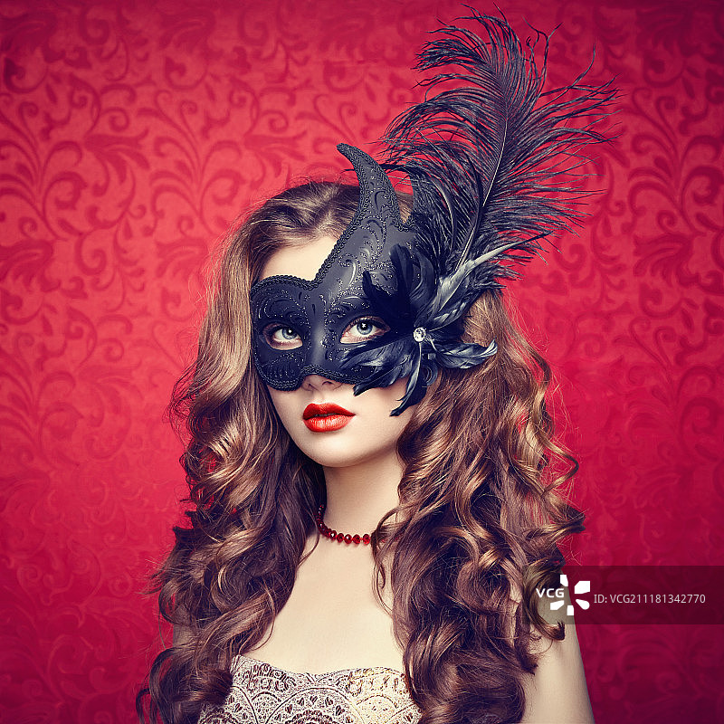 美丽的年轻女子戴着神秘的黑色威尼斯面具。时尚的照片图片素材