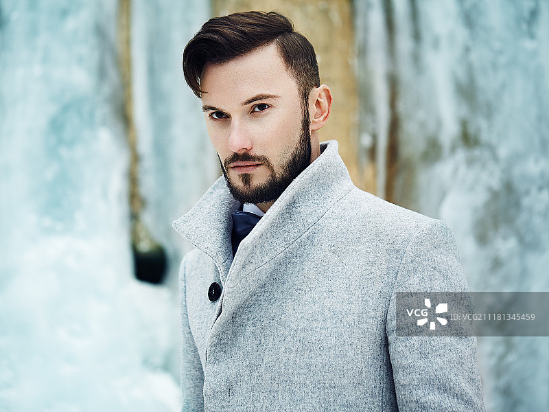 户外肖像英俊的男子在灰色大衣。时尚照片。美丽的冬季风格图片素材
