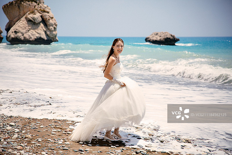 户外肖像年轻美丽的女人新娘在海滩上穿着婚纱佩特拉图罗米欧图片素材