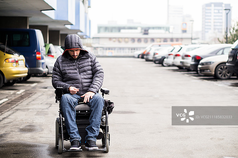 年轻，成人轮椅使用者在一个有复印空间的停车场图片素材