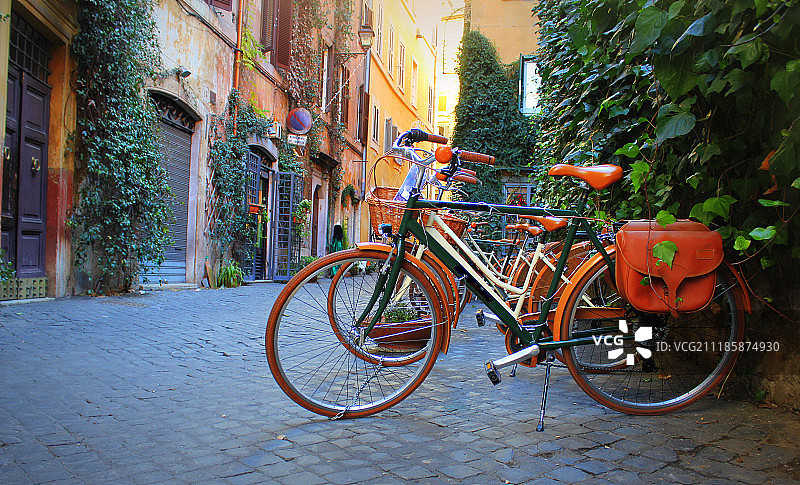 站在罗马老街商店前的自行车图片素材