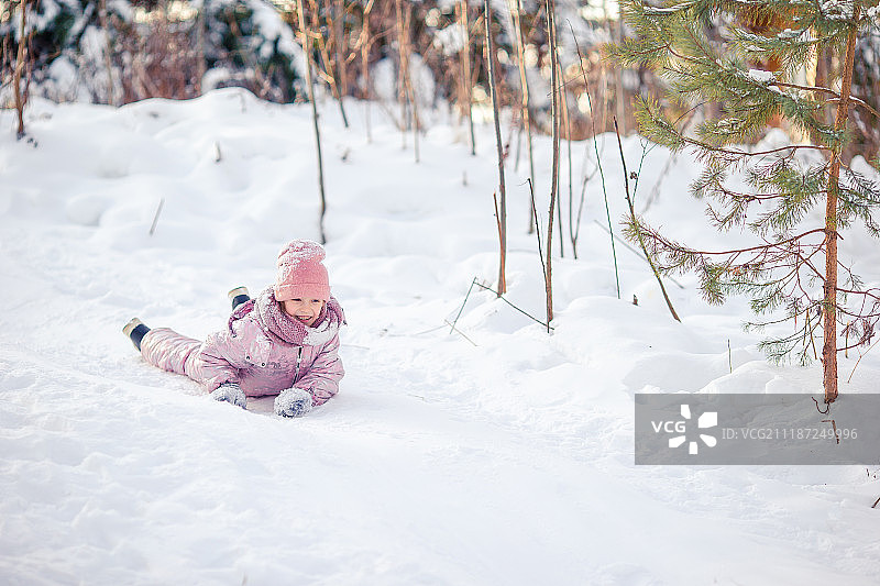 可爱的快乐小女孩在冬天下雪的雪橇图片素材