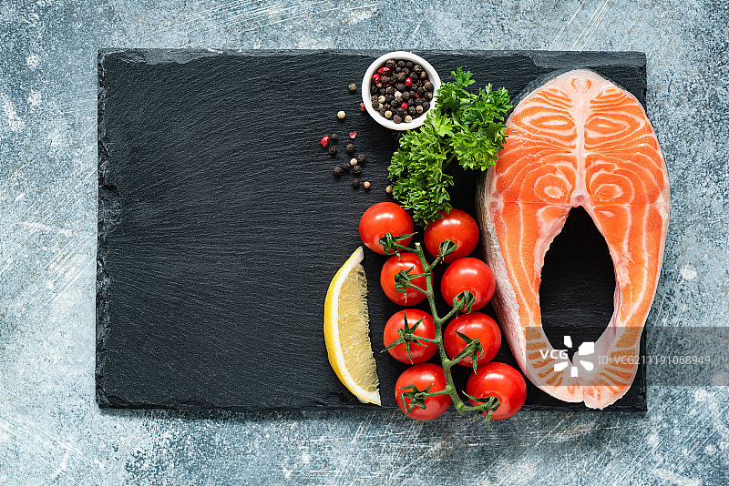 采购产品生鲑鱼牛排，蔬菜和香料烹饪板岩图片素材