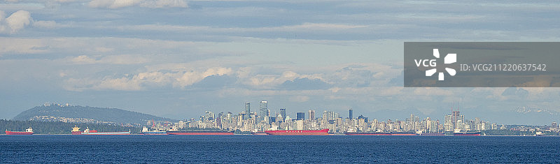 加拿大不列颠哥伦比亚省，温哥华海滨天际线和前景的货船图片素材