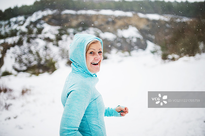 资深女跑步者在冬天的自然中休息。图片素材