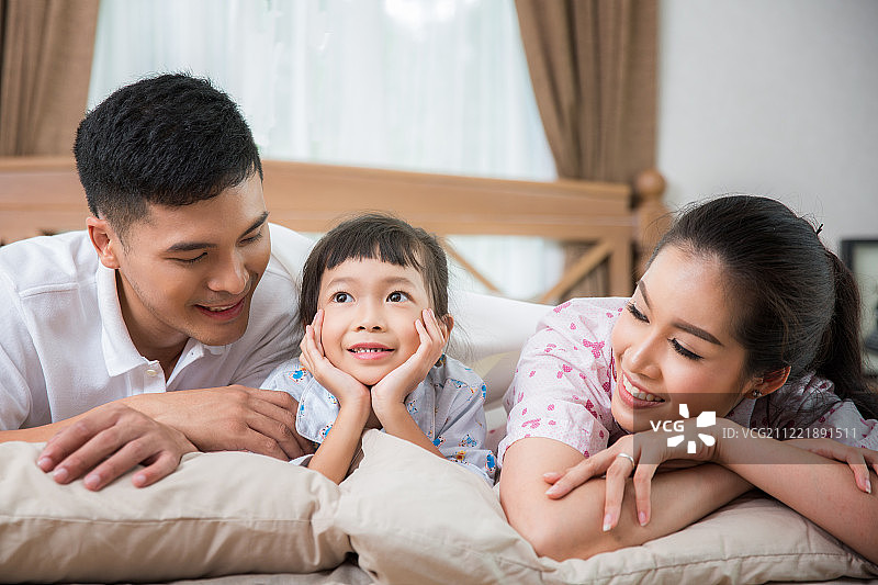 一个亚裔家庭在床上，爸爸图片素材