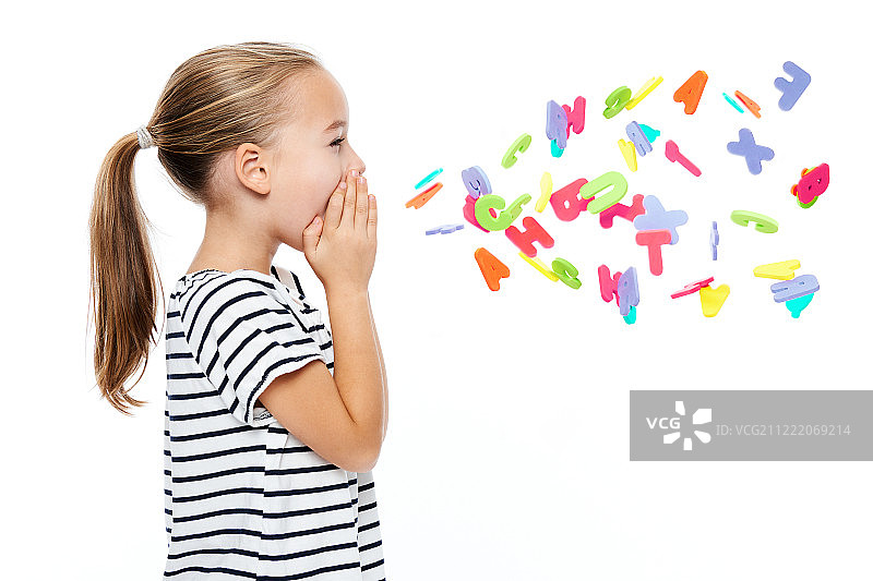 可爱的小女孩穿着条纹t恤喊着字母。语言治疗的概念结束了…图片素材