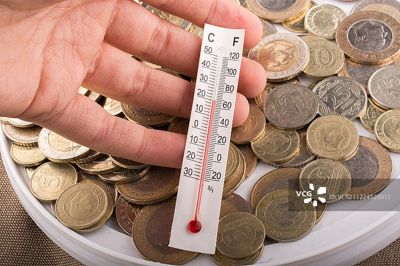 土耳其里拉硬币旁边的温度计图片素材