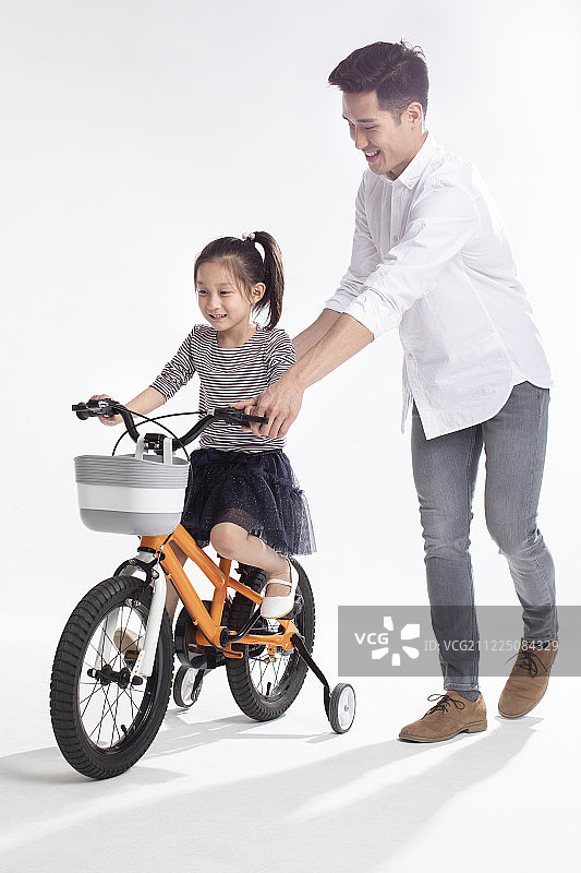 父亲教女儿骑自行车图片素材