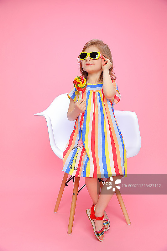 可爱的女孩戴着太阳镜和棒棒糖图片素材