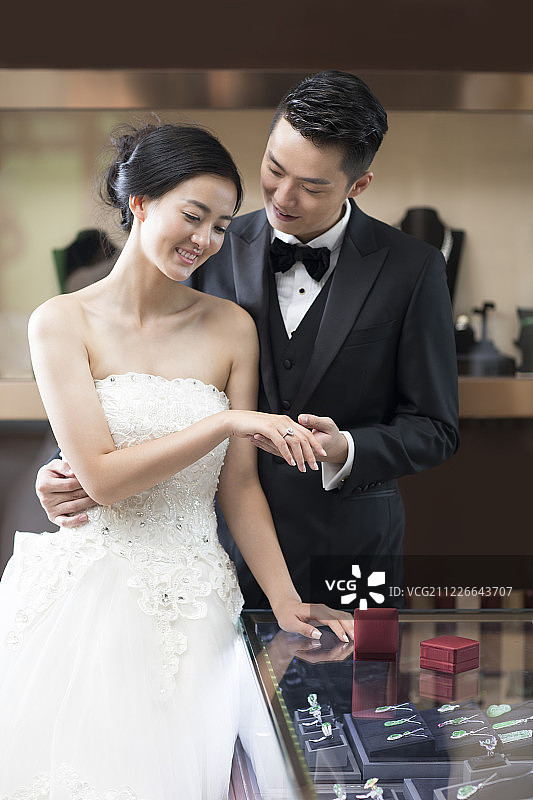 幸福的新娘和新郎在珠宝店挑选戒指图片素材