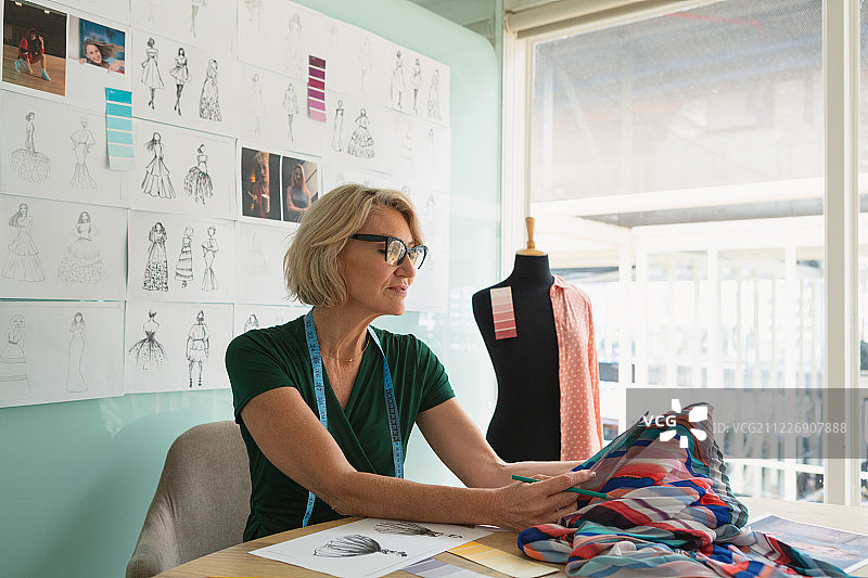 女时装设计师在桌子上检查颜色图片素材