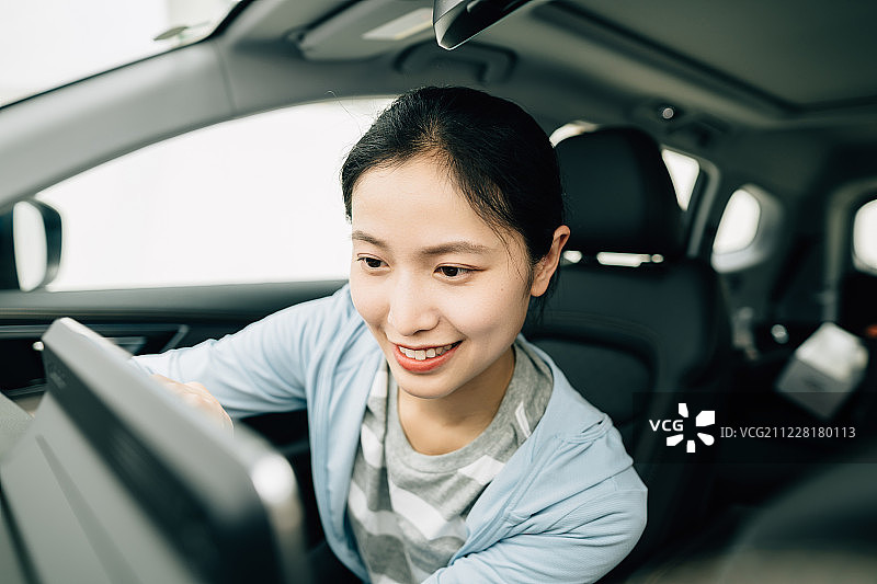 年轻女性在车内操作电子设备图片素材