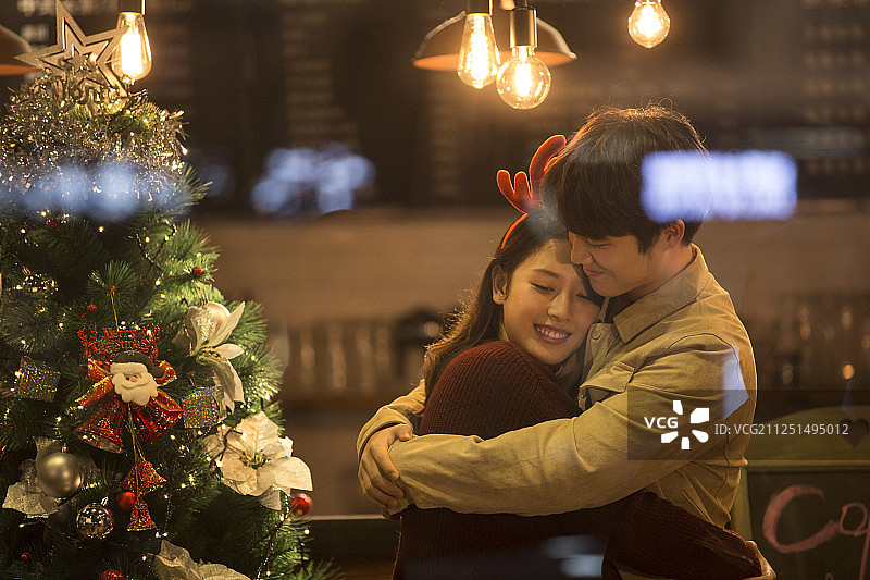 甜蜜情侣在咖啡馆拥抱约会共度平安夜和圣诞节图片素材