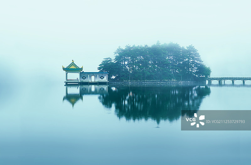 迷雾中的中式传统亭台楼阁在湖面上投下倒影图片素材