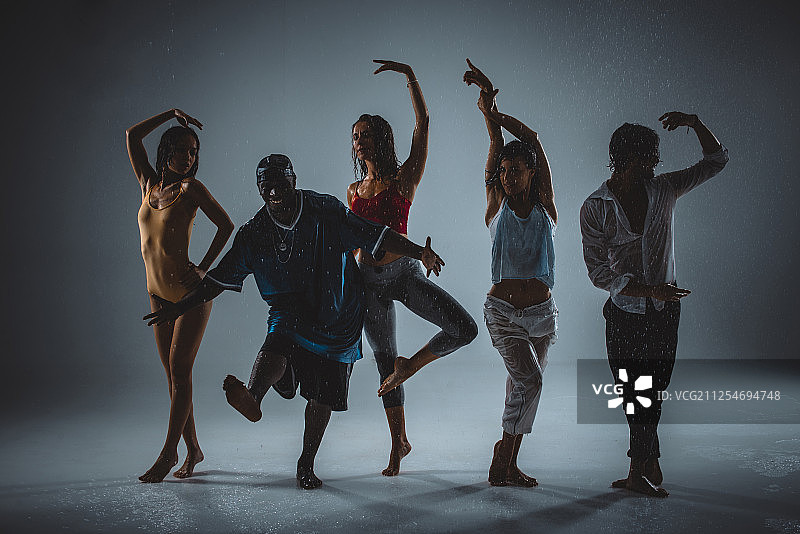 一群舞者在舞台上以雨的效果跳舞图片素材