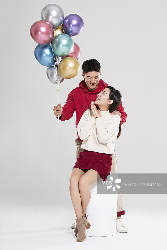 快乐的年轻情侣拿着气球图片素材