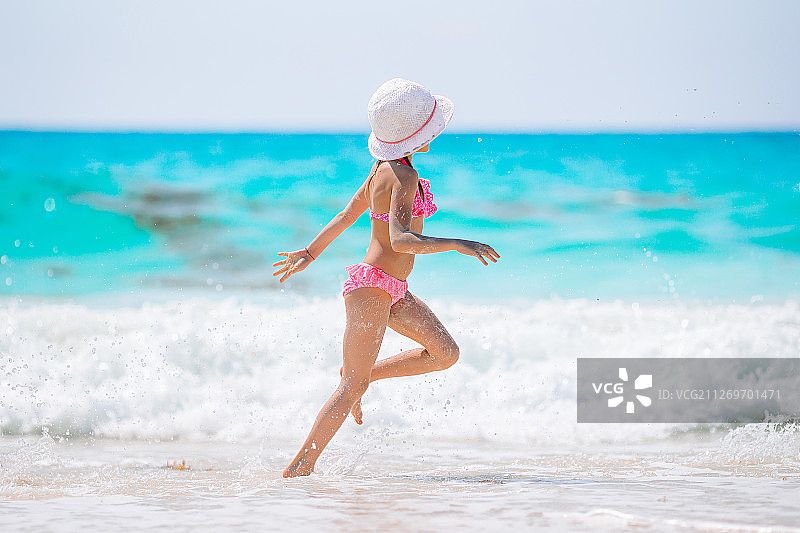快乐的小女孩在加勒比度假海滩散步图片素材