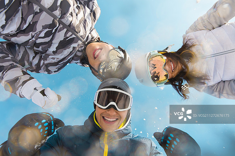 三个青年男女在户外滑雪场扔雪花嬉戏玩耍图片素材