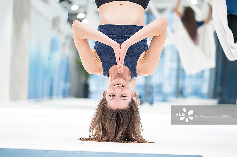 在吊床上倒挂的女人飞行瑜伽课图片素材