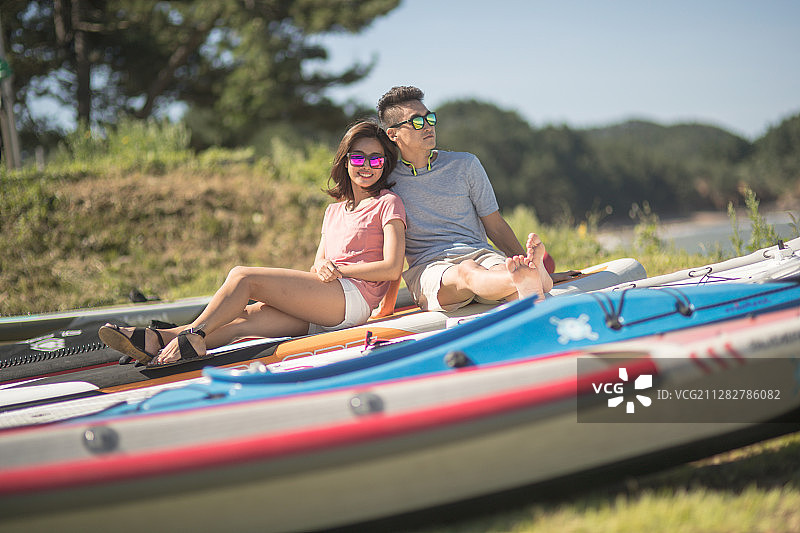 一对夫妇戴着墨镜坐在水上的船上图片素材