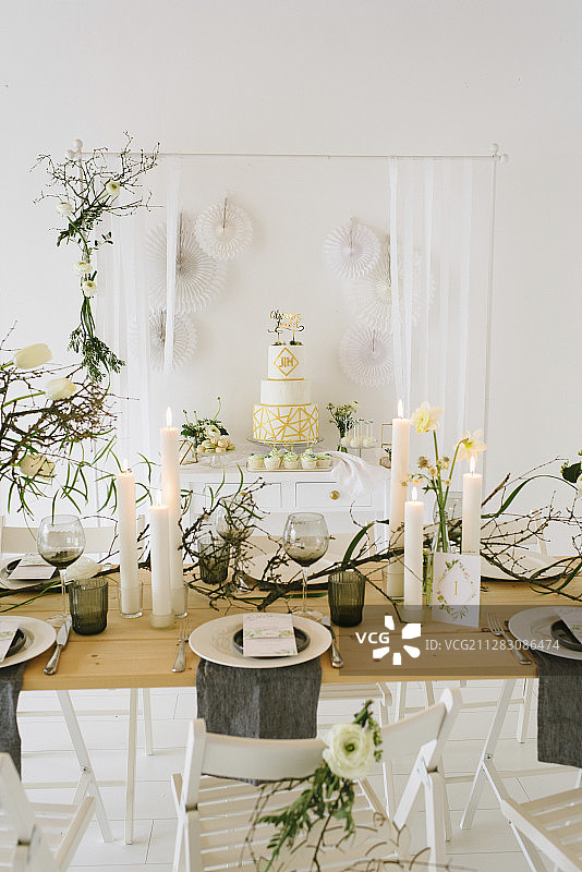 婚礼用的桌子上有花瓶，郁金香，枯枝和柱状蜡烛图片素材
