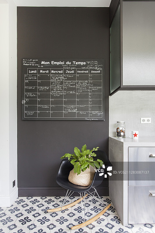 黑色墙壁上的黑板，厨房橱柜旁边的经典摇椅图片素材