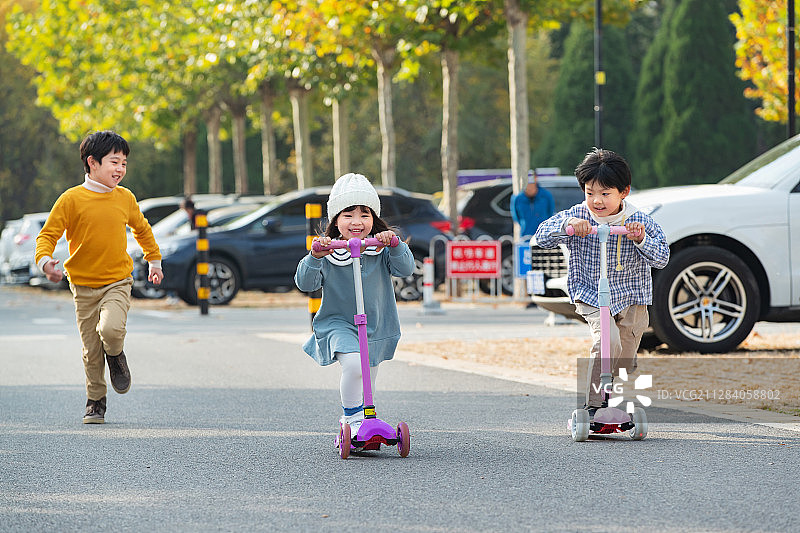 快乐的儿童在户外玩滑板车图片素材