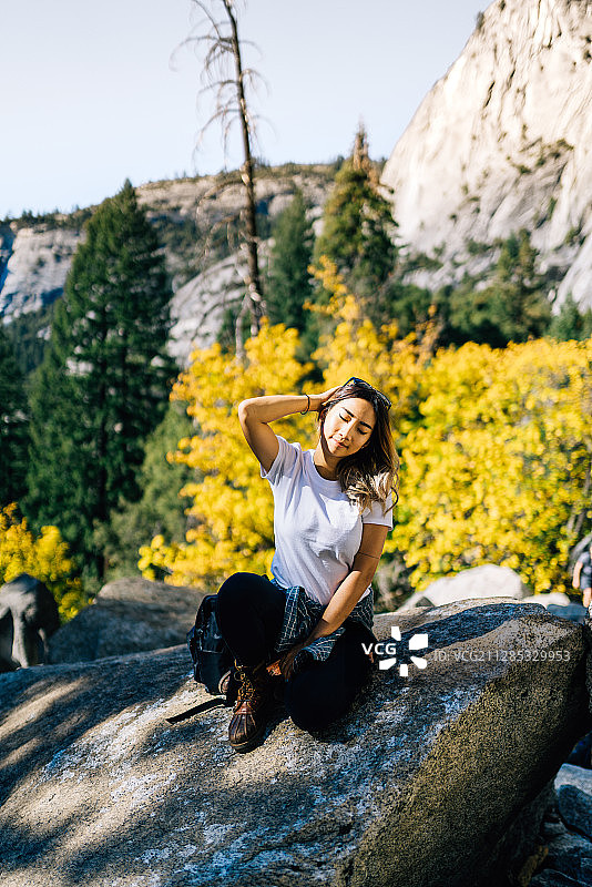年轻女孩(18-19岁)在岩石上摆姿势，约塞米蒂国家公园，美国加利福尼亚州图片素材