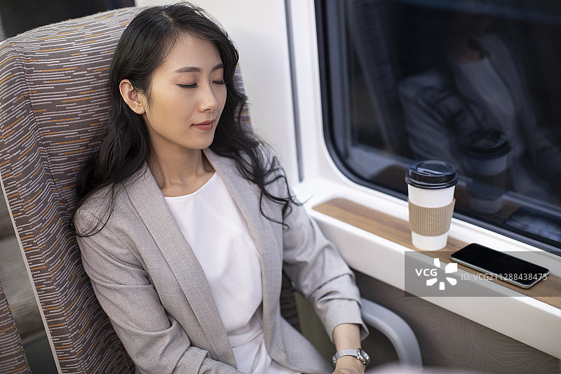 年轻商务女士在高铁上休息图片素材