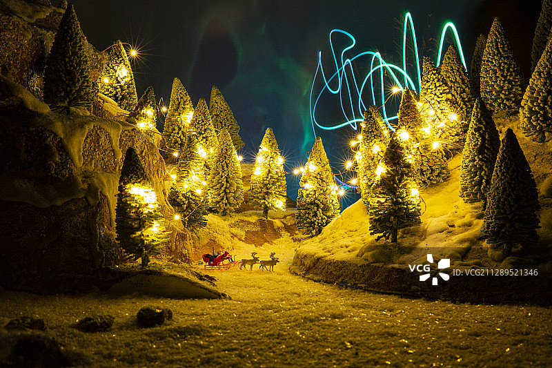 夜晚极光人偶圣诞老人驾着驯鹿雪橇车送礼物静物图片素材