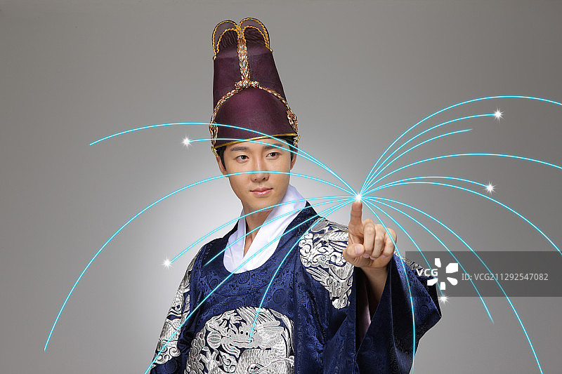 穿着传统韩国服饰的男子指着光束的焦点图片素材