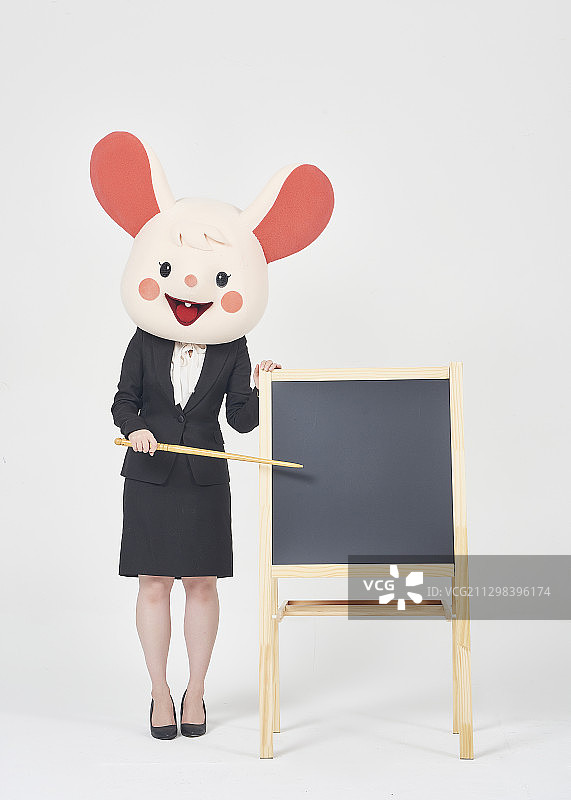 女商人戴着鼠标面具站在黑板旁边用棍子指着黑板图片素材