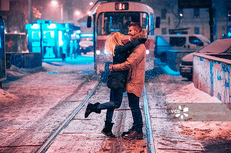 一对年轻的夫妇在被雪覆盖的电车线上图片素材