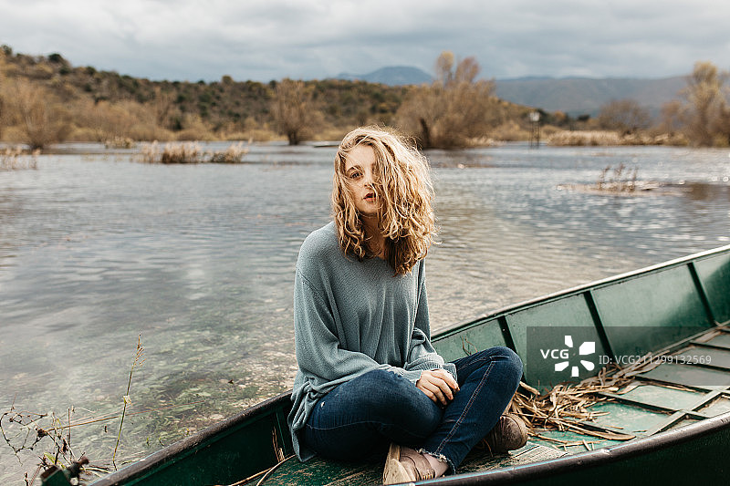 克罗地亚波德戈拉，坐在独木舟上的年轻女子图片素材