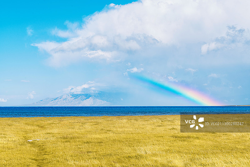 云层雪山彩虹湖泊和金黄的草原组成的圣山图片素材