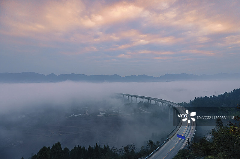 日出时的彩云，地面升起云海漫过高架桥。图片素材