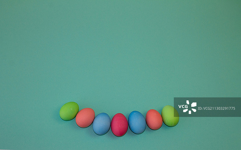高角度的彩色复活节彩蛋在绿色的背景图片素材