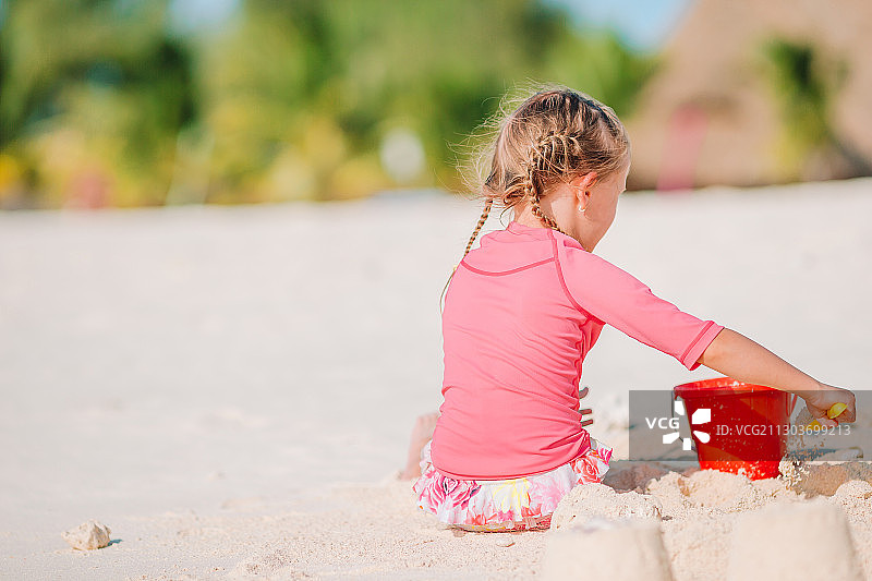 女孩在沙滩上玩沙子图片素材