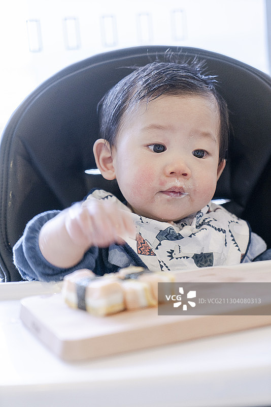宝宝吃三文鱼寿司时的可爱表情图片素材
