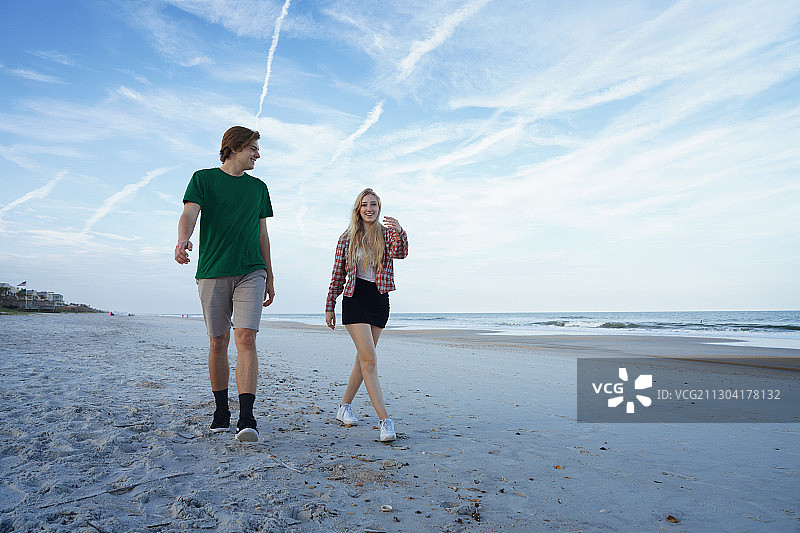 一对年轻的情侣在海滩上约会图片素材