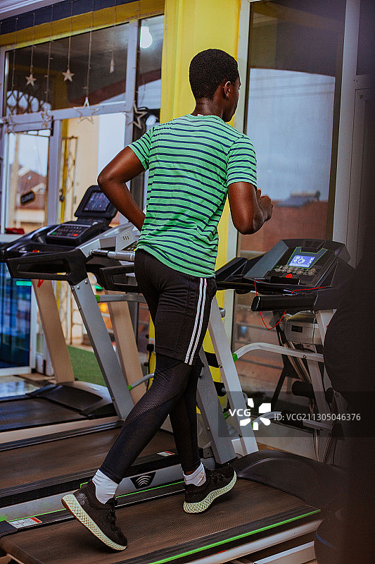 一名年轻黑人男子在加纳特马体育馆的跑步机上跑步图片素材