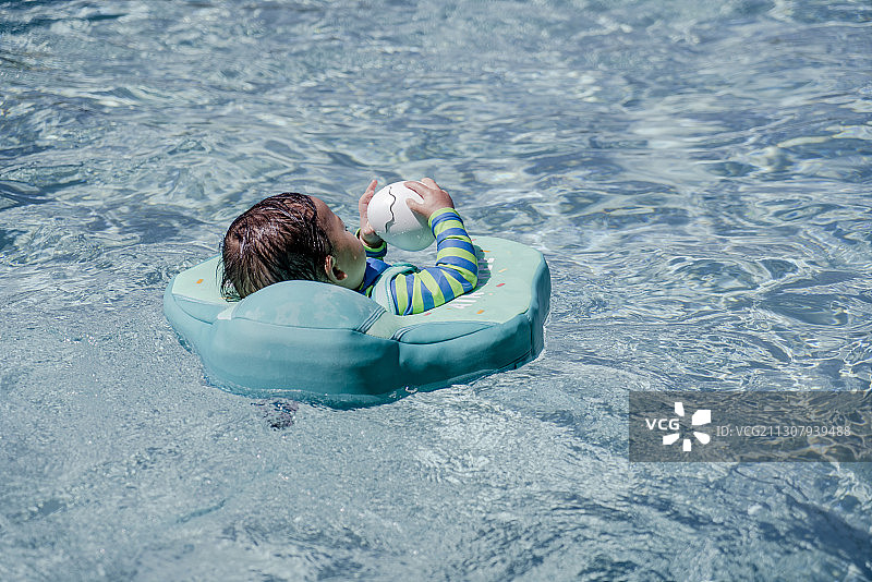 婴儿与玩具鸭在泳池游泳图片素材