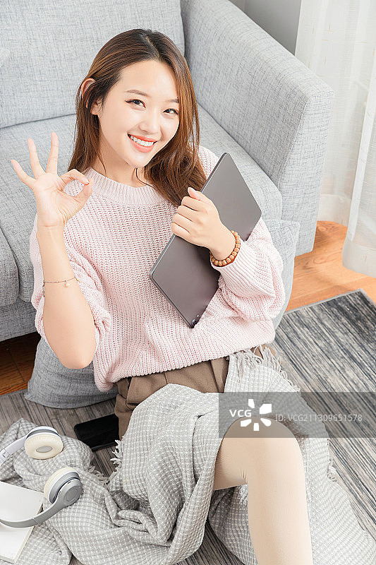 坐在地毯上使用平板电脑的亚洲女孩图片素材